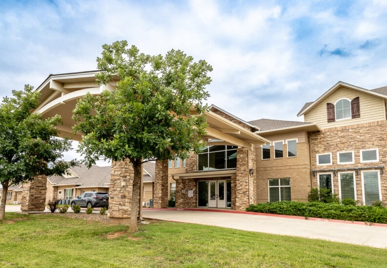 Exterior View of Senior Living Community With Covered Entrance and Landscaping at Assisted Living Facility