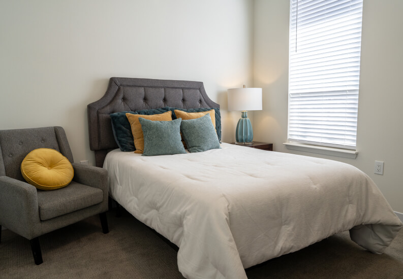 Private Bedroom With Bedside Table and Comfortable Seating at Memory Care Facility