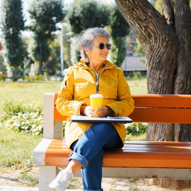 cheerful-senior-freelancer-park-bench-with-laptop-and-coffee cheerful-senior-freelancer-park-bench-with-laptop-and-coffee